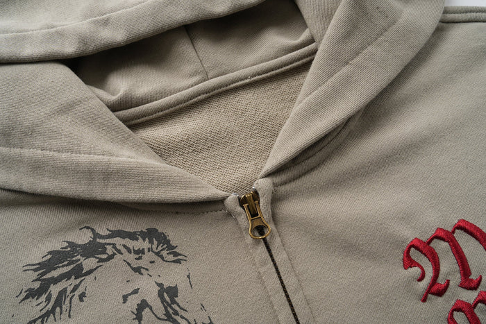 Close-up of taupe hoodie front zipper and chest graphic print