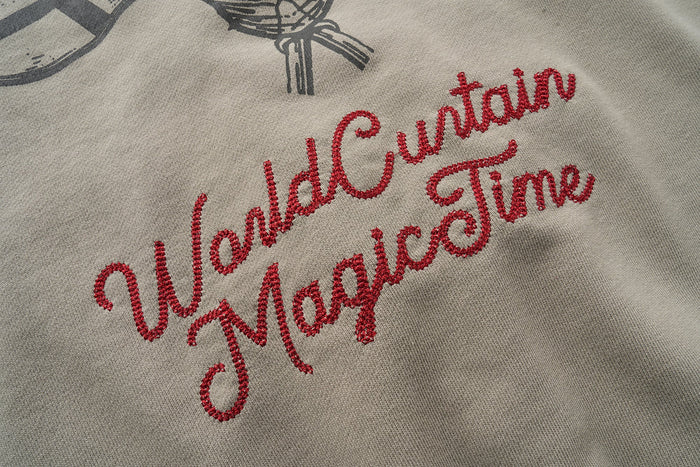 Close-up of red embroidered script text on the back of a taupe hoodie