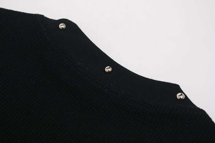 Black graphic T-shirt with a textured fabric edge and silver snap buttons on a clean white background