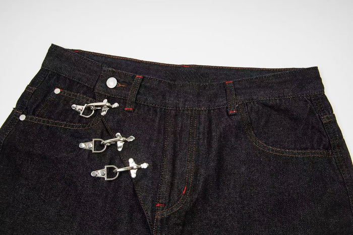 Close-up of front waistband and hook closures on dark wash denim pants