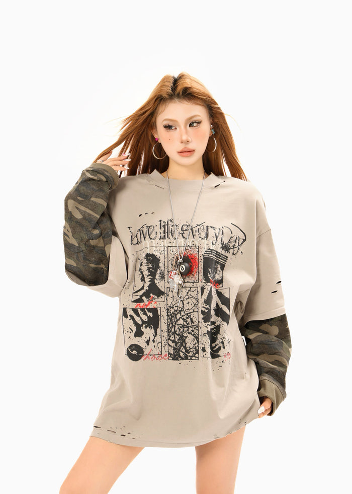 Model wearing beige distressed graphic tee with camo long sleeves and oversized fit