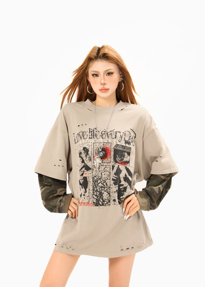 Front view of oversized beige graphic tee with camouflage sleeves and ripped neckline details