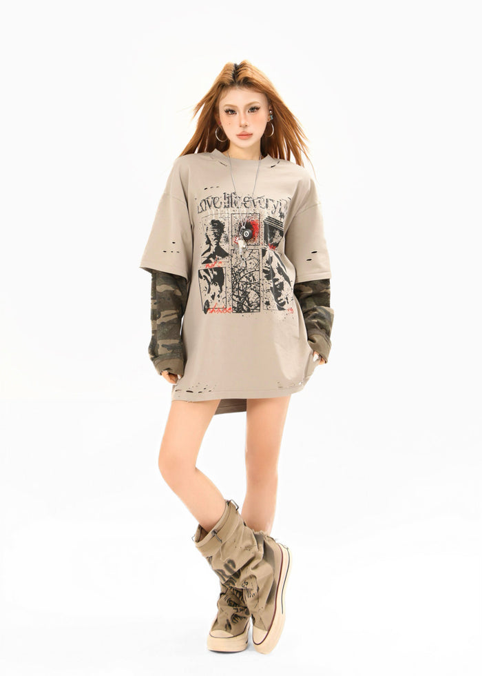 Model posing in beige distressed tee with camo sleeves and front graphic print