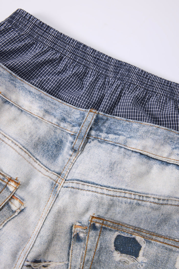 Close-up of plaid elastic waistband layered under light wash jeans