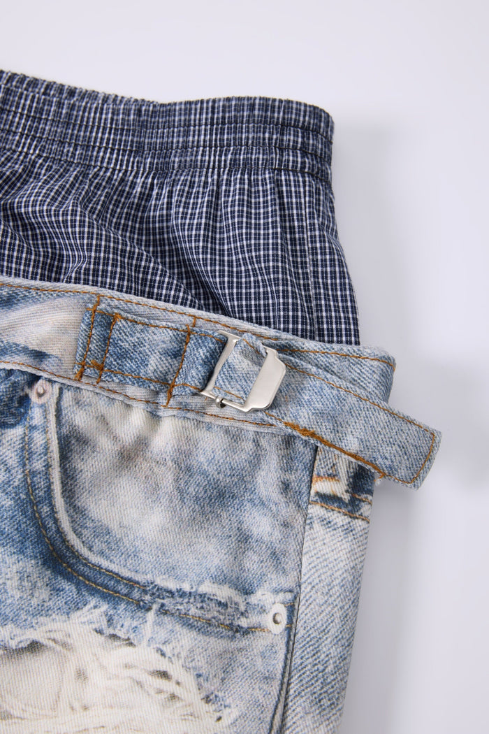 Side waist close-up of plaid elastic waistband and belt buckle on distressed jeans