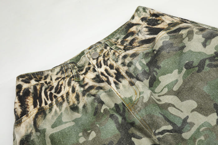 Close-up of front waistband on leopard camo cargo shorts with button closure and stitched pocket