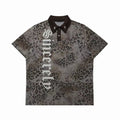 Oversized grey leopard print polo shirt with gothic lettering graphic and metallic star collar pins, front view