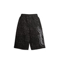Front view of black leopard print loose shorts with white script graphic on the leg