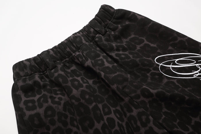 Close-up of black leopard print shorts waistband and white script graphic