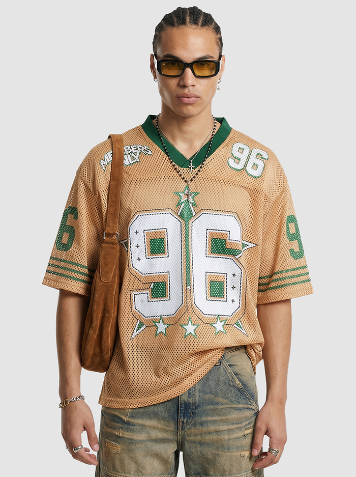 Tan mesh jersey T-shirt with green trim and large 96 graphic, styled on a model with a brown shoulder bag and sunglasses