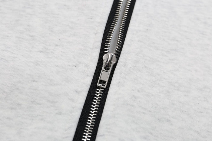 Close-up of silver zipper on ash grey cotton zip-up hoodie
