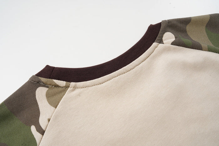 Close-up of a camo raglan T-shirt with beige body, brown ribbed collar, and olive camouflage sleeves