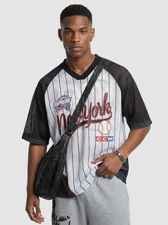 Model wearing a black mesh New York pinstripe jersey T-shirt with oversized graphic front and V-neck styling