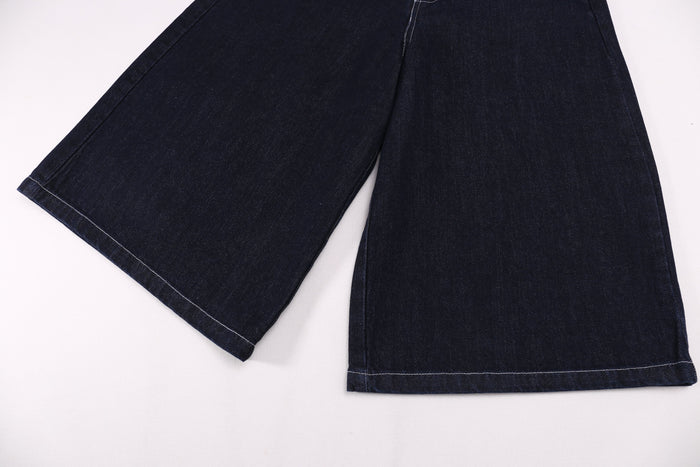 Wide-leg dark denim shorts shown from the hem with clean stitched cuffs