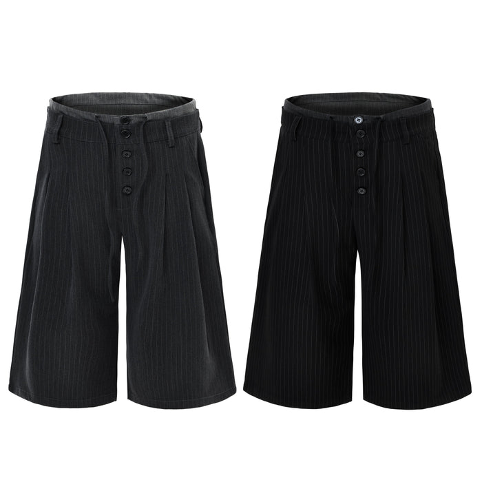Black pinstripe wide-leg shorts with exposed button fly and layered waistband, shown in black and charcoal grey colorways