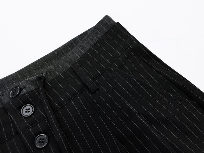 Close-up of black pinstripe shorts waistband and top front buttons