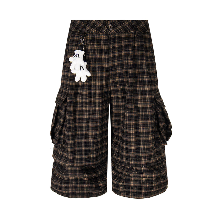Front view of black and brown plaid cargo shorts with hanging white keychain