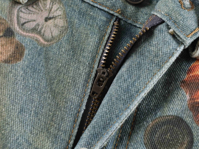 Close-up of the front zipper opening on printed denim jeans