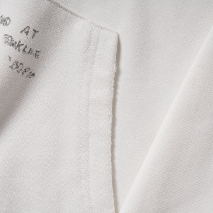 Close-up of hoodie kangaroo pocket and printed text near the hem