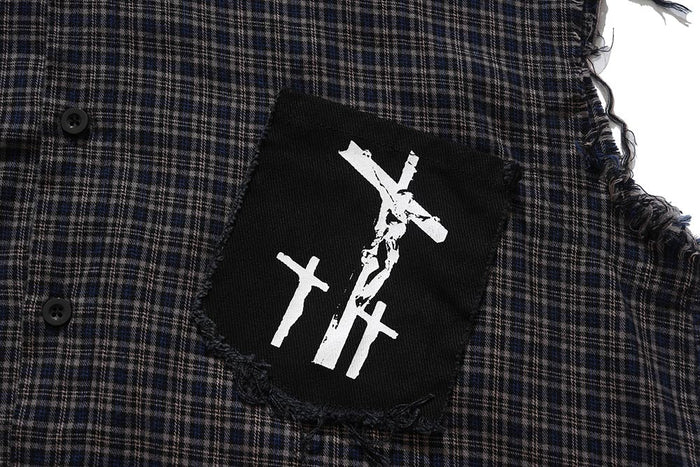 Close-up of black chest patch with white graphic on dark plaid shirt