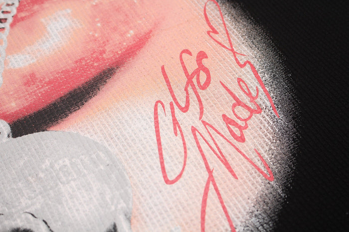 Close-up of a black oversized T-shirt with a pink lip graphic and red Seakoff script print