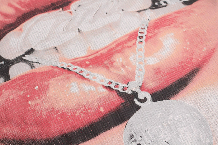 Close-up of a pink and red lip graphic with rhinestone chain details on an oversized Y2K streetwear T-shirt