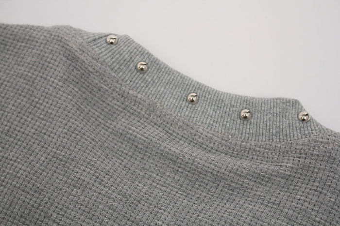 Close-up of a gray waffle knit gothic tee with ribbed collar and silver studded trim details