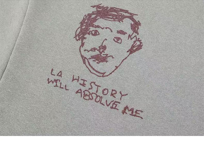 Close-up of a sketched face and handwritten text on the light gray sweatshirt back
