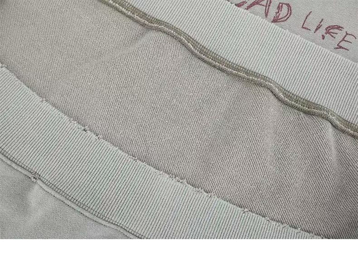 Close-up of sweatshirt interior seams and ribbed hem on light gray fabric