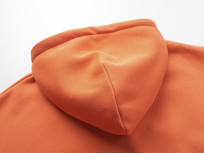 Close-up of orange hoodie hood seam and smooth fabric texture