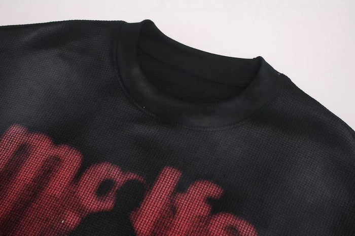 Close-up of black oversized washed tee with red shadow figure graphic and ribbed crew neckline