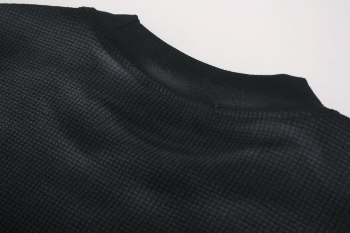 Black washed oversized streetwear tee with textured fabric and ribbed crew neck close-up