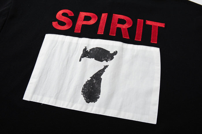 Black gothic polo tee with red SPIRIT lettering and a white graphic patch on the front