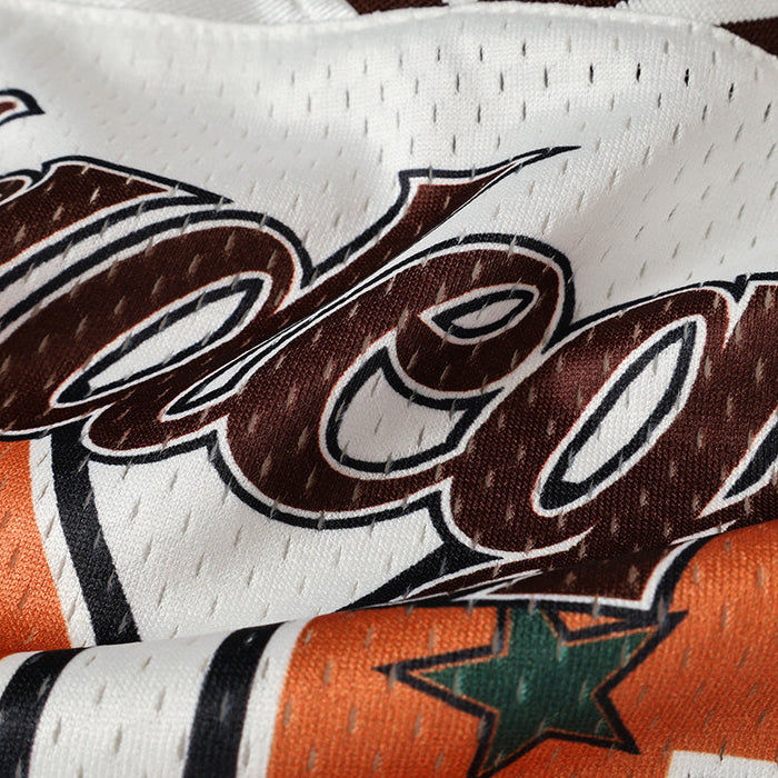 Close-up of white mesh varsity jersey with brown script lettering and orange panel with green star detail