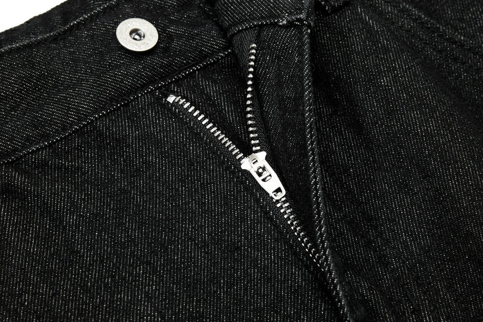 Close-up of black jeans fly with silver zipper and button