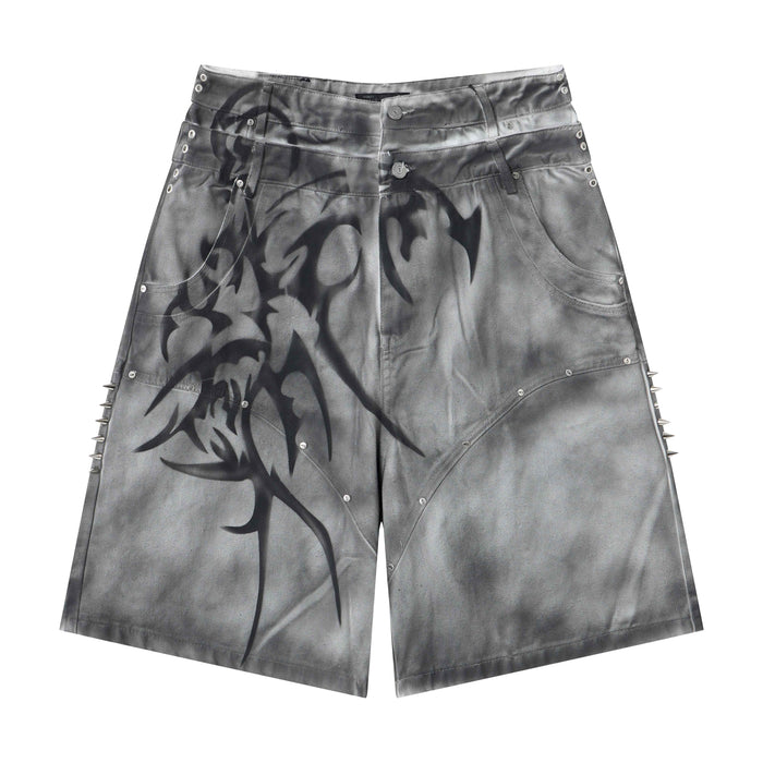 Grey washed wide-leg denim shorts with airbrushed tribal graphics and metal spike side seam accents, front view