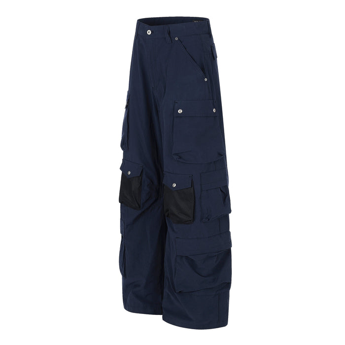 Angled front view of navy wide-leg cargo pants with flap pockets and mesh pocket details