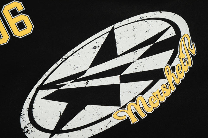 Close-up of black sweatshirt front graphic with distressed white logo and yellow retro lettering
