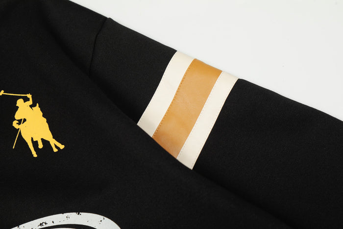 Black sweatshirt sleeve close-up with cream and tan stripe trim and small rider graphic