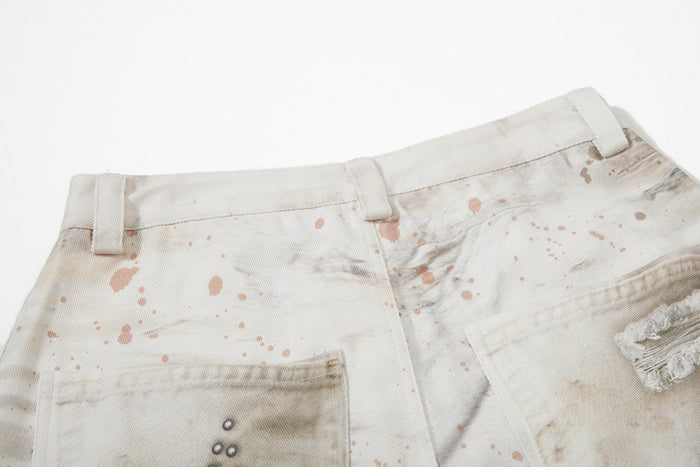 Back waistband close-up of cream jeans with belt loops and splatter print