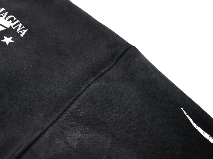 Close-up of black jersey shoulder and sleeve seam with partial front print
