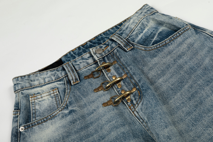 Close-up of the front waist on light wash jeans showing metal hook closures and button tab