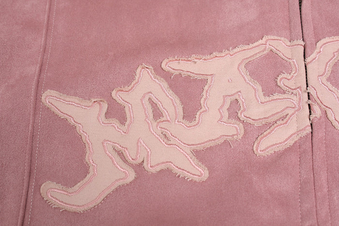 Close-up of pink hoodie chest graphic with frayed gothic lettering