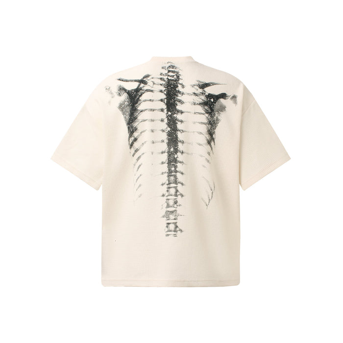 Cream oversized tee with black x-ray ribcage graphic on the back, featuring a bold streetwear skeleton print