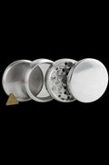 A disassembled Metal 4-Piece Grinder, showing its four silver metal sections arranged in a circular view.