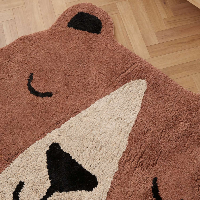 Bear-shaped rug on a wooden floor