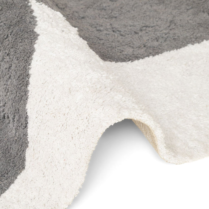 Close-up of a textured gray and white rug with a geometric pattern.