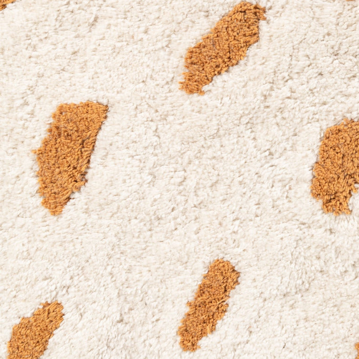 Close-up of a beige carpet with brown patches