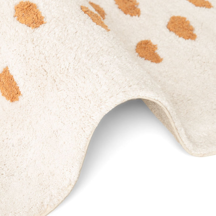 Close-up of a beige rug with brown spots on a white background