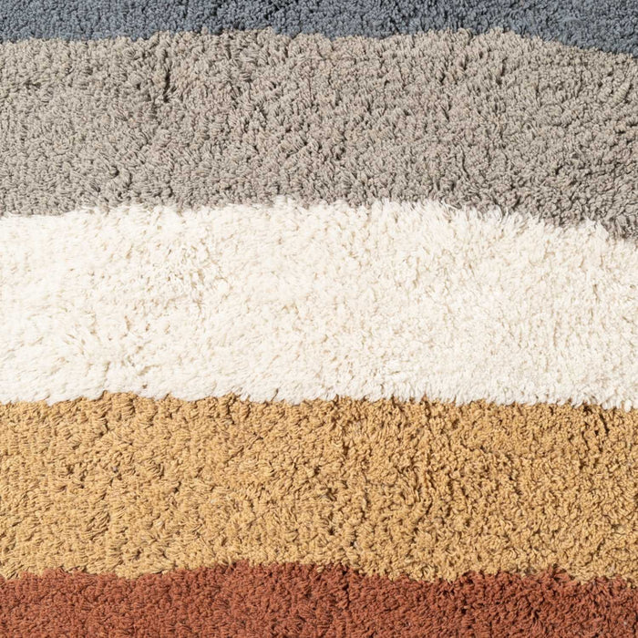 Close-up of a textured rug with horizontal stripes in gray, white, beige, and brown.